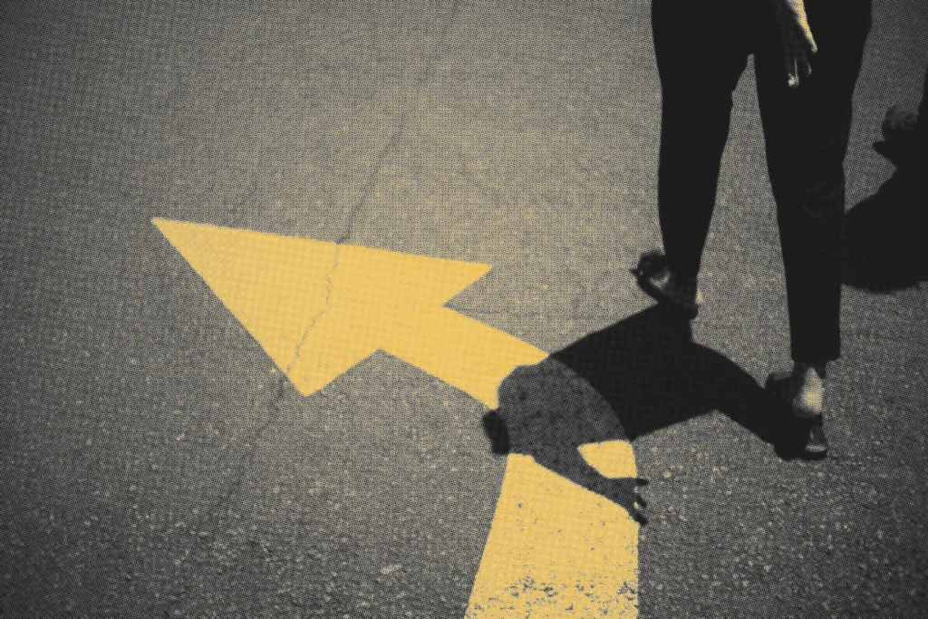 yellow arrow going left on the street with someone going in that direction