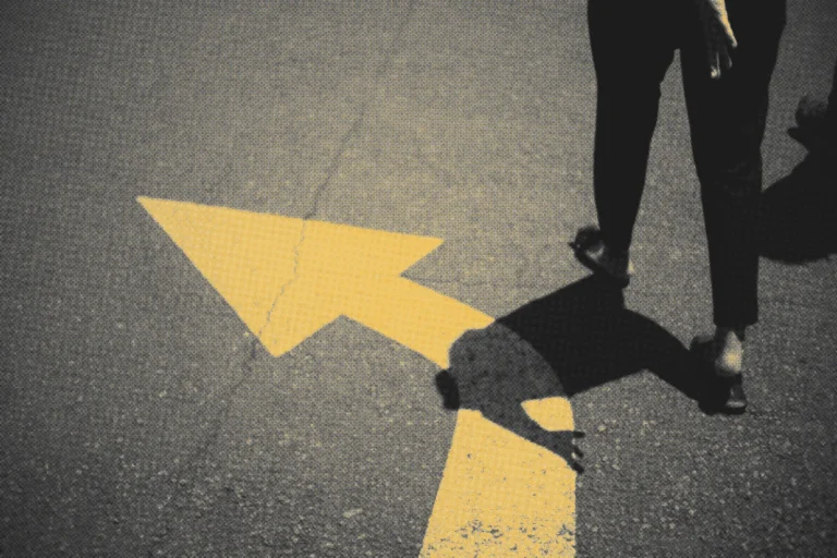 yellow arrow going left on the street with someone going in that direction