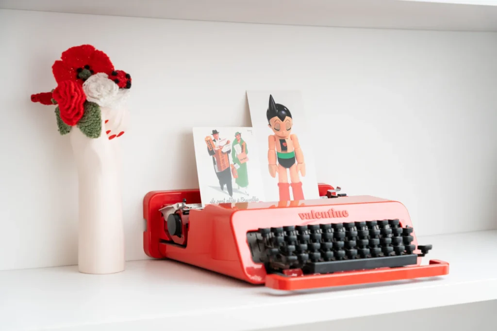 Red typewriter on a shelf with decoration